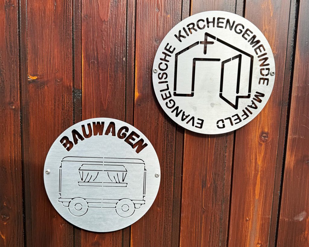 Logos von Bauwagen und Kirchengemeinde gefräst ins Alluminium